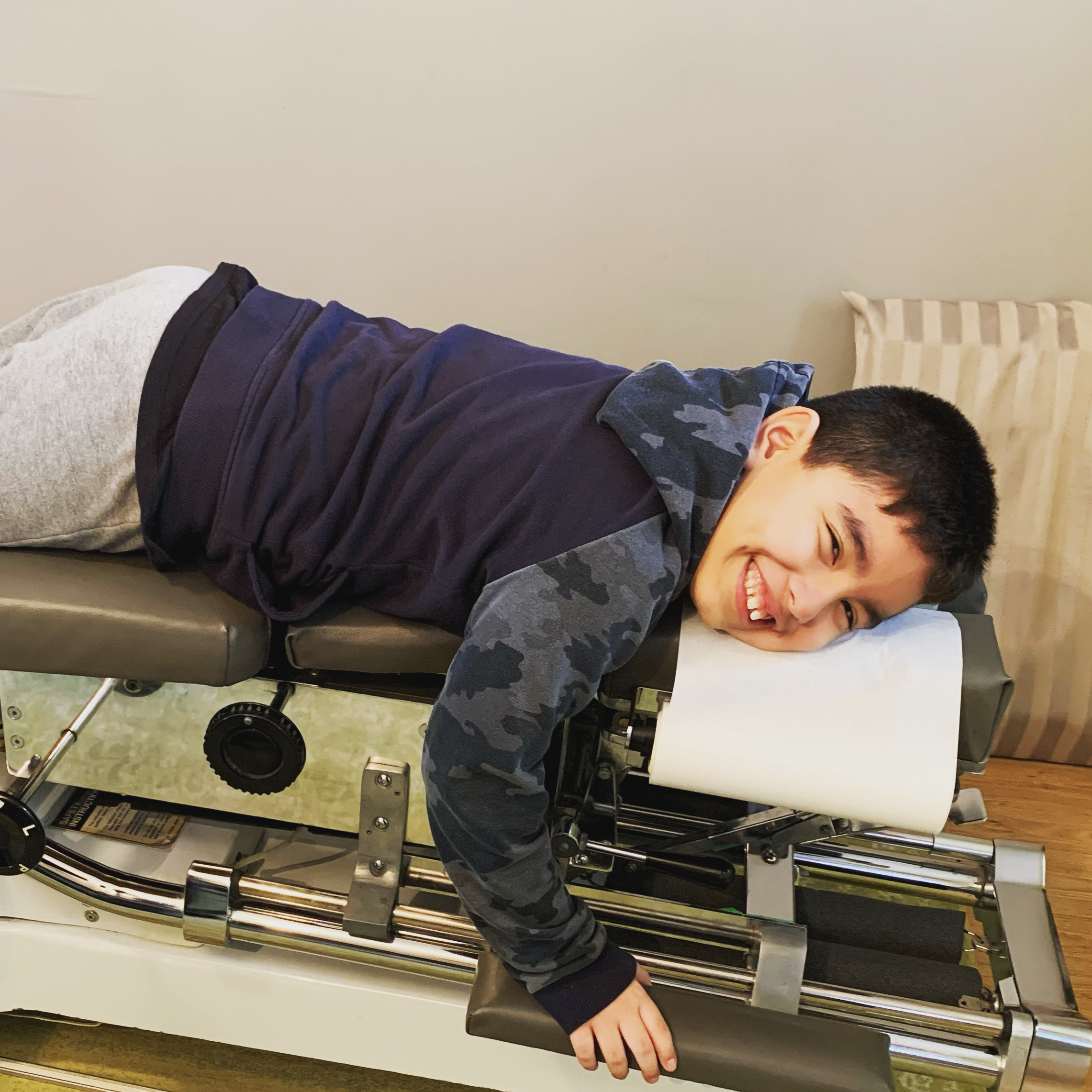 Young boy laying on treatment table smiling