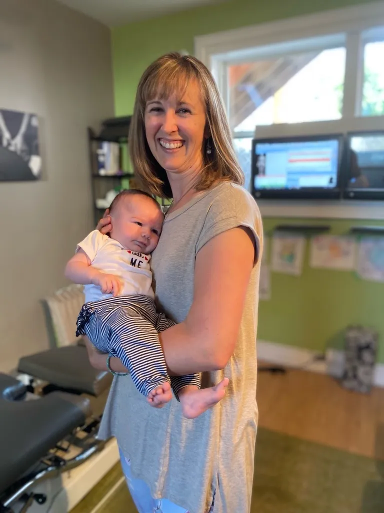 Dr. Emilie Perras holding an infant at Oaktree Chiropractic Downtown Ottawa